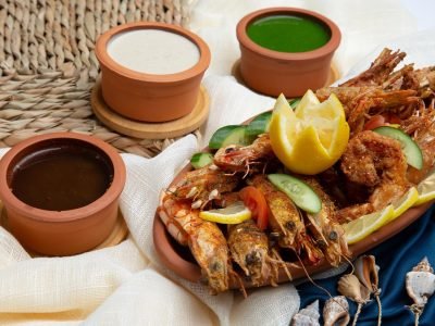 جمبري مقلي ومشوي على طبق فخاري مع الصلصات